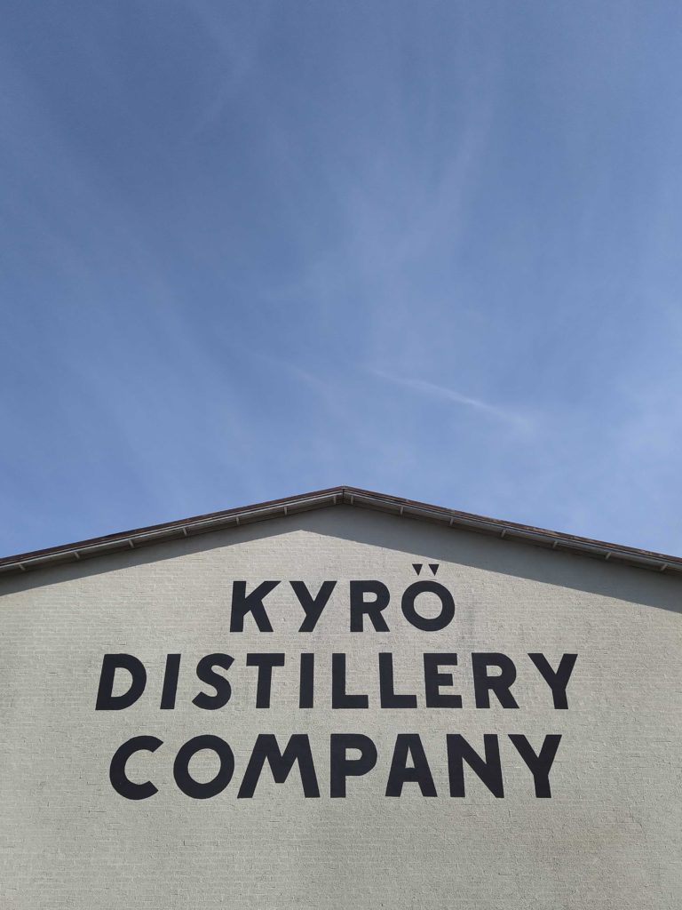 Kyrö distillery companyn rakennus, logo taivasta vasten