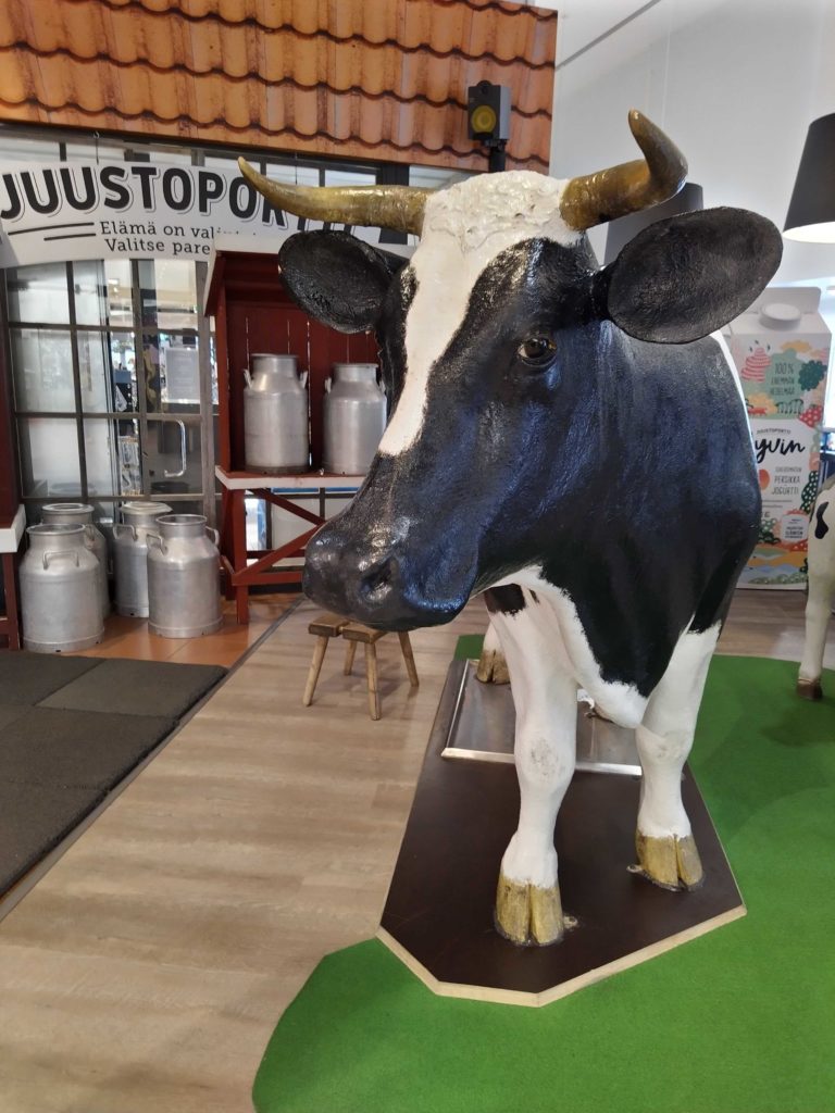 Juustoportin lypsättävä lehmäpatsas myymälän sisällä