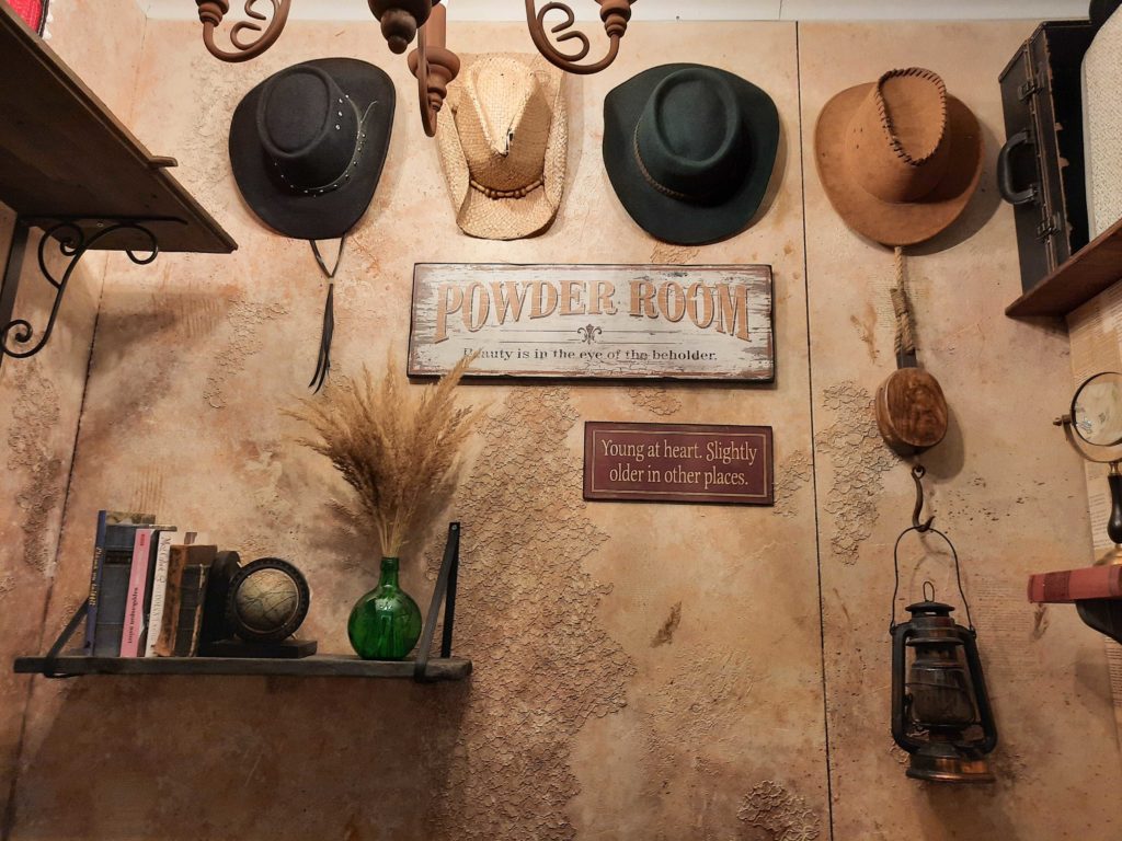 western tyyliin sisustettu vessa - seinällä "länkkäri"hattuja