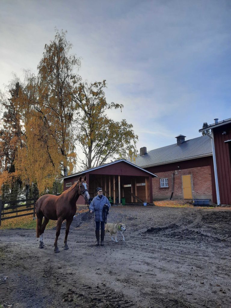 Siirilän Tilan Liisa Helmi hevosen kanssa tallipihassa