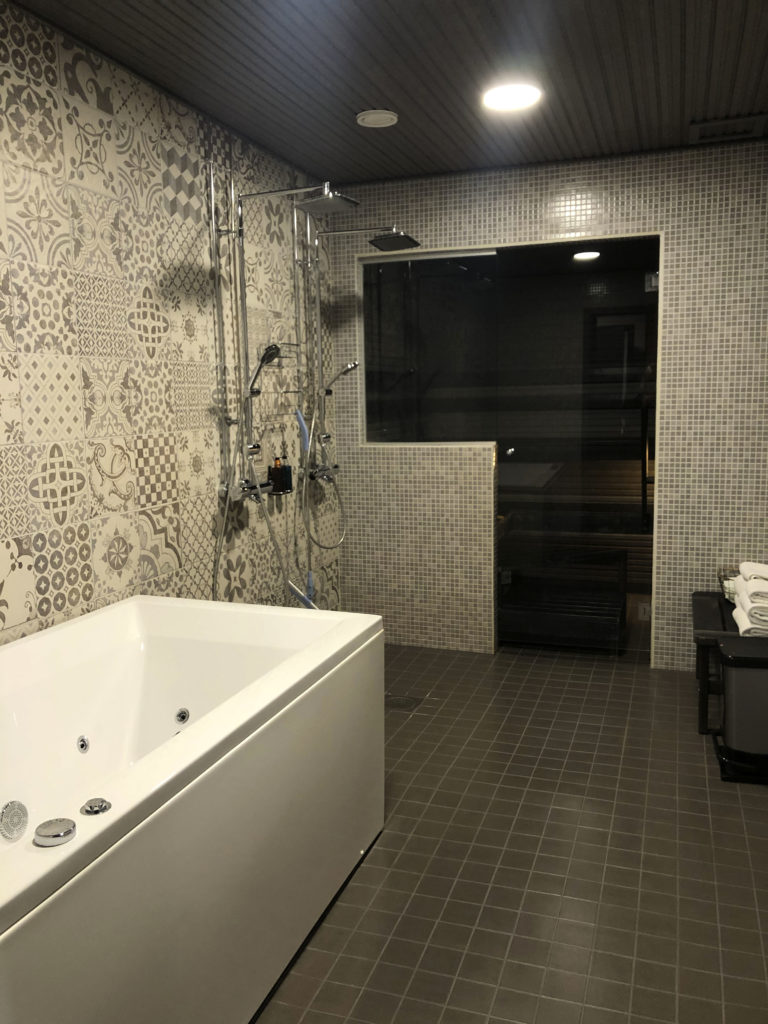 Kylpyhuone, jossa kylpyamme ja koristeelliset laatat