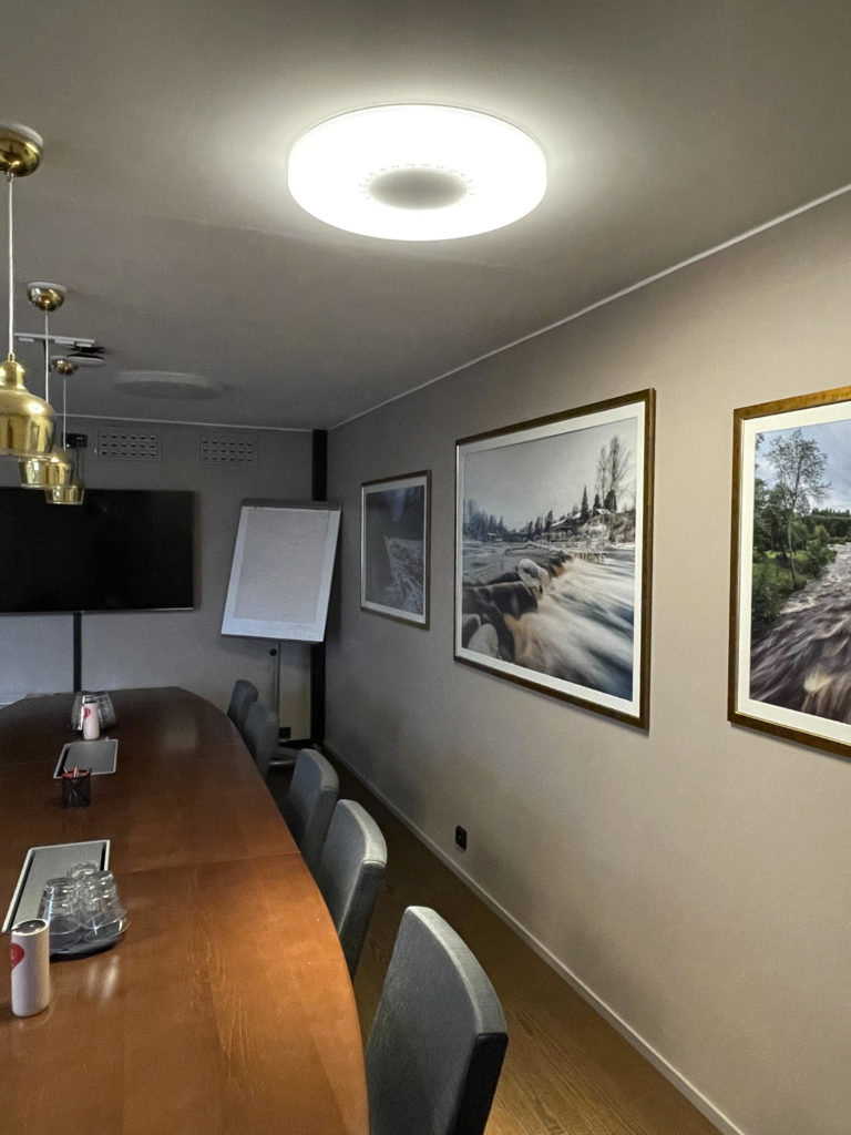 Vaakunan kokoustila, pitkäpöytä ja taulut seinällä
