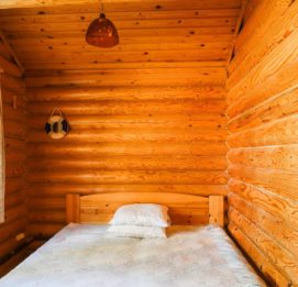 Kalajärven Lomakylä - Aurinkopirtin makuuhuone. Perinteiset puunväriset seinät koristavat huonetta.
