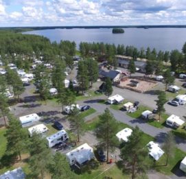 Caravan Kalajärvi matkaautot ja vaunut leirintäalueella järvimaisemissa.