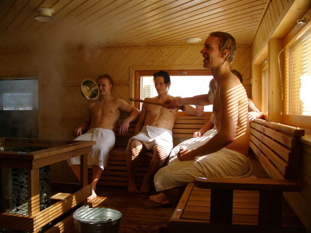 Ryhmä saunoo pyyhkeet päällä.