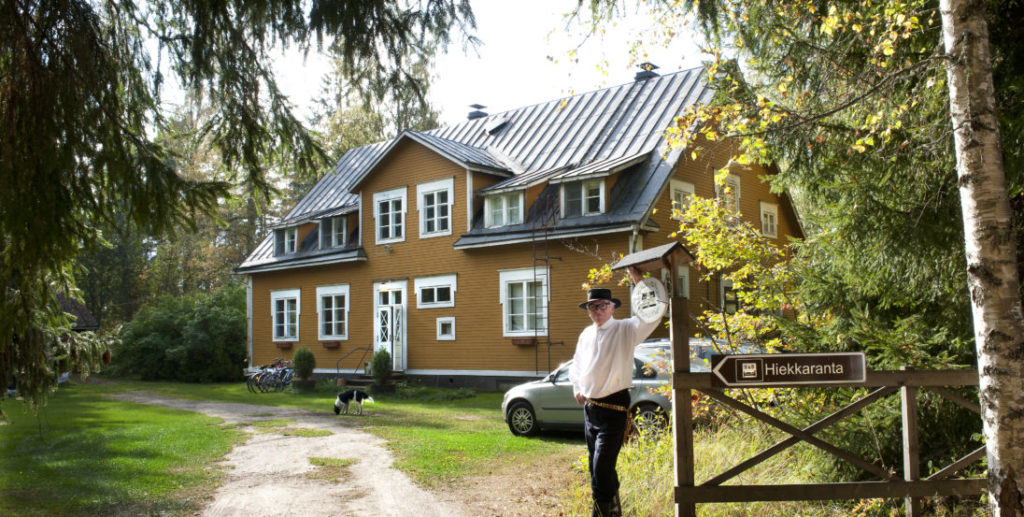Talon isäntä Kristian nojaa Hiekkaranta bed and breakfastin porttiin.
