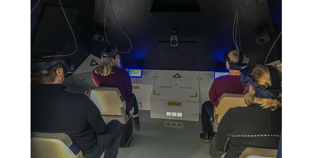 Virtuaalimatka avaruuteen. Vierailijat virtuaalitodellisuus lasit päässään avaruusaluksen näköisessä huoneessa.