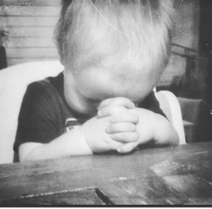 Pieni lapsi rukoilemassa